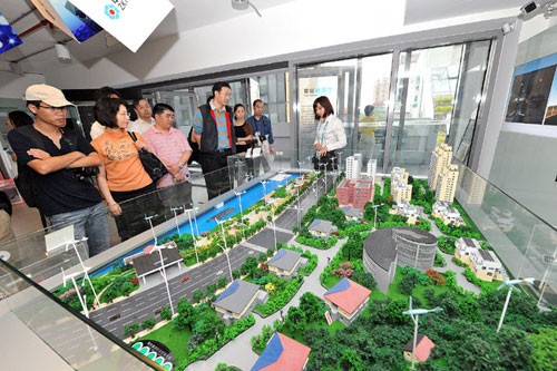 游客在世博園“倫敦零碳館”觀看模型（6月4日攝）